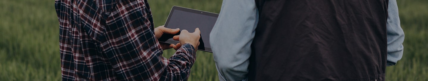 Agricultural business owner and employee buying insurance from Nationwide on a tablet.