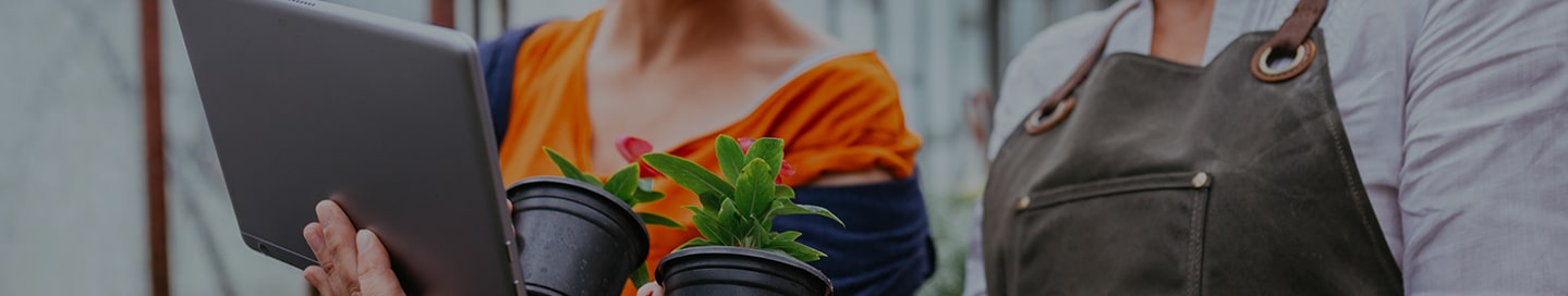 A small business owner of a garden center reviewing their insurance from The Hanover with an employee