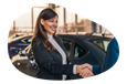 An employee shakes hands with a customer in a car dealership's showroom.