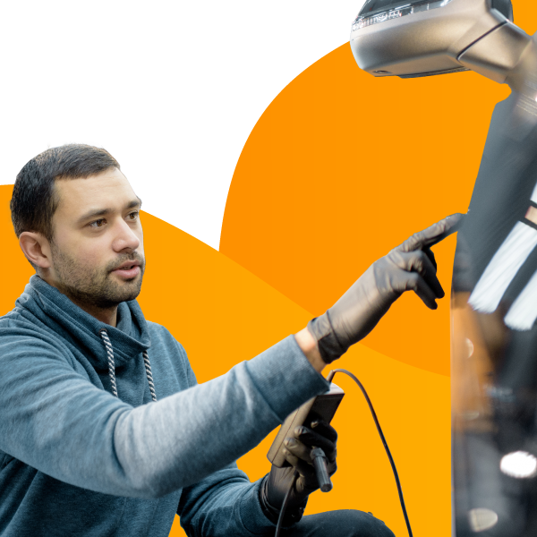 An employee at an auto detailing company works on a customer's car.