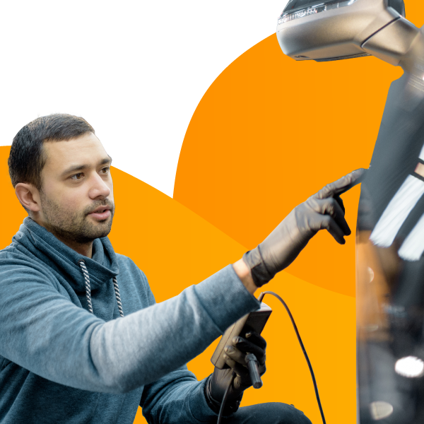 An employee at an auto detailing company works on a customer's car.