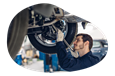 A mechanic works on a customer's car elevated on a lift.