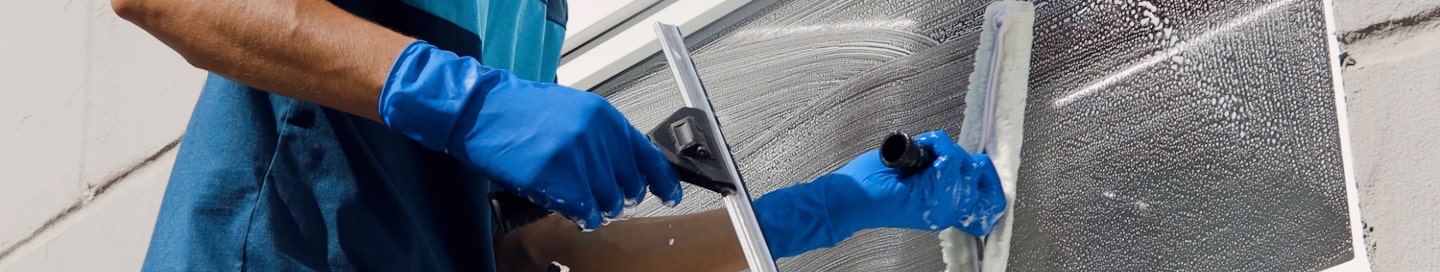 A window cleaner employee washing a window.