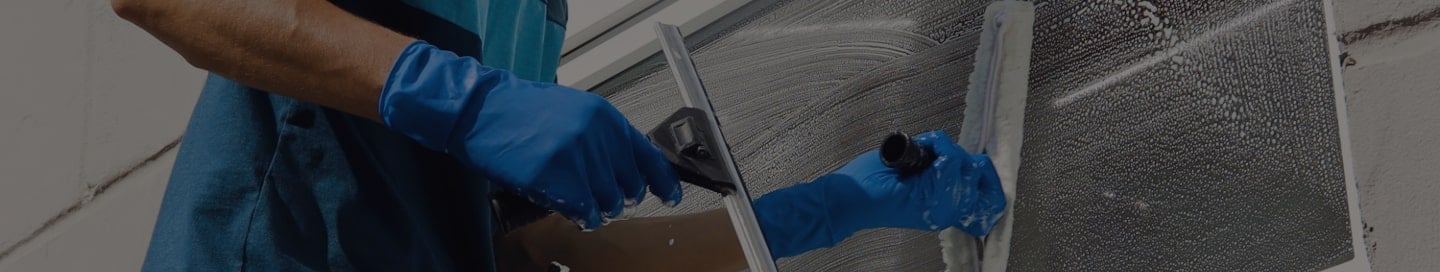 A window cleaner employee washing a window. A window cleaner employee washing a window.