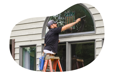 A window cleaner employee washing a window.