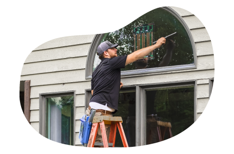 A window cleaner employee washing a window. A window cleaner employee washing a window.