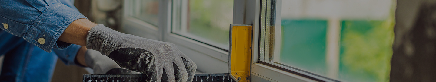 A window installer making sure the window is square with the wall.