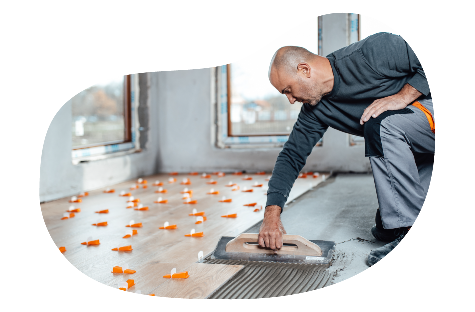 Flooring contractor installing wood floor boards.