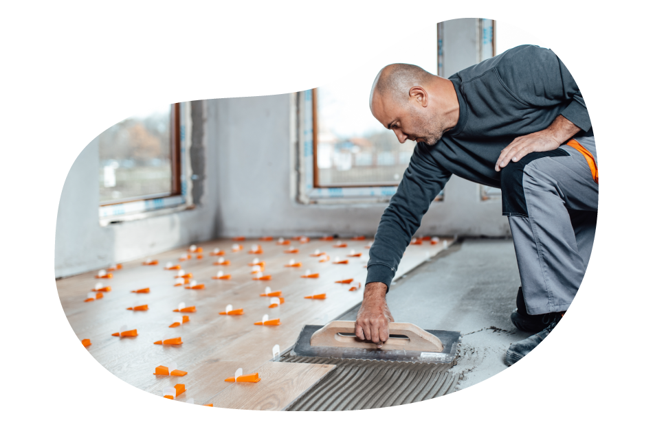 Flooring contractor installing wood floor boards.