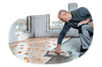 Flooring contractor installing wood floor boards.
