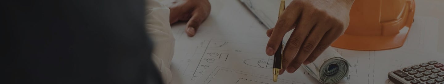 A general contractor mapping out their construction plan with a subcontractor. A general contractor mapping out their construction plan with a subcontractor.