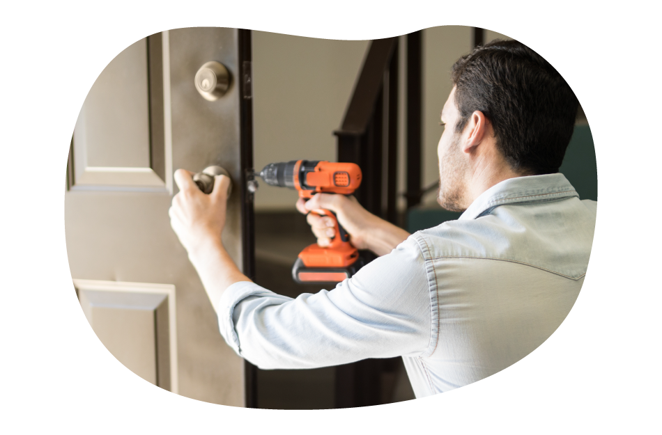 A handyman installing a doorknob at a client's property A handyman installing a doorknob at a client's property
