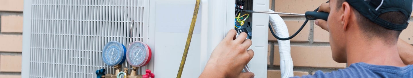 An HVAC contractor repairing a customer's AC unit An HVAC contractor repairing a customer's AC unit