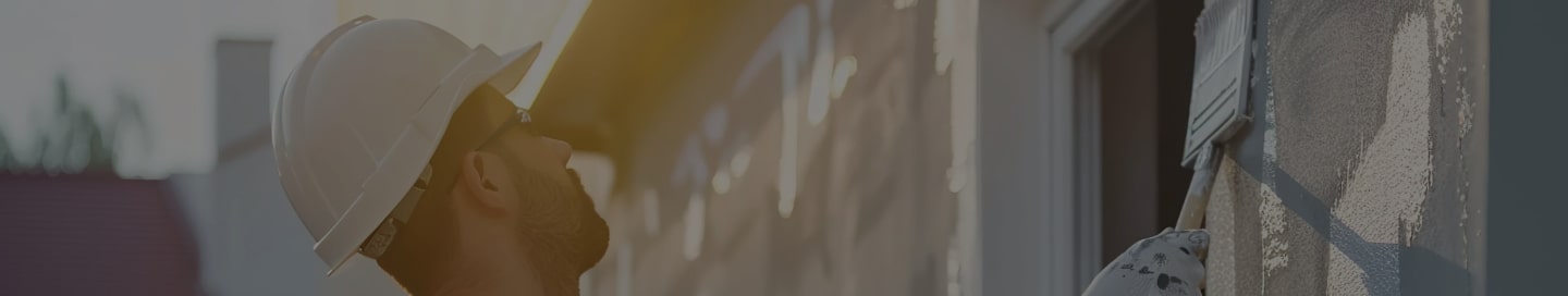 Painting contractor cutting in an outdoor painting job.