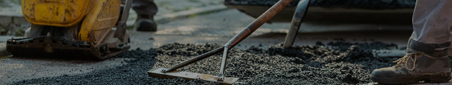 A paving contractor spreading asphalt. A paving contractor spreading asphalt.