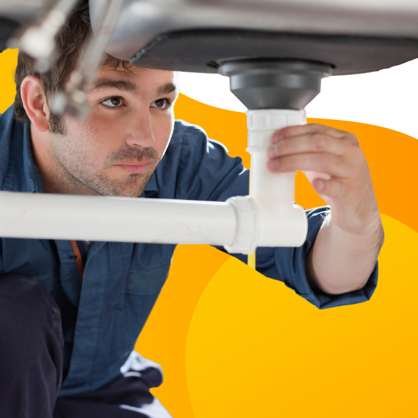 A plumber works on a customer's sink.