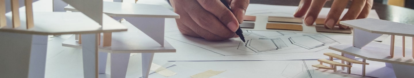 An architect works on a blueprint for their latest house development project An architect works on a blueprint for their latest house development project