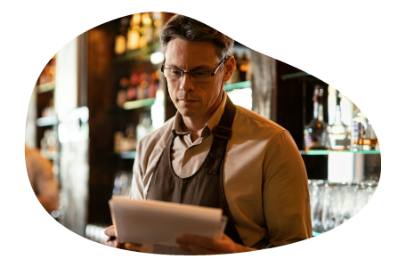A restaurant owner looks over documents. A restaurant owner looks over documents.