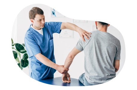 A chiropractor works on a patient's arm and shoulder.