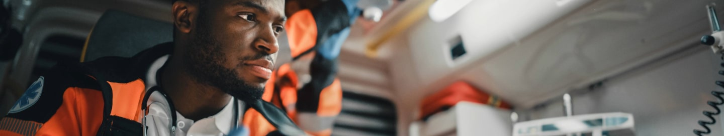 An EMS professional documenting notes on their tablet as they look after a patient 
