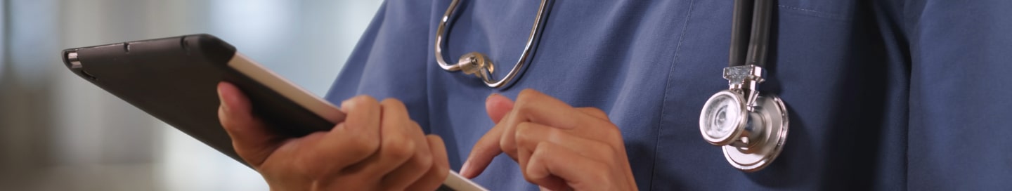 A healthcare professional doing work on a tablet.