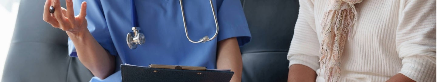 A home healthcare provider speaking with a patient. A home healthcare provider speaking with a patient.