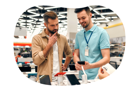 Computer store employee showing smartphones to a customer.