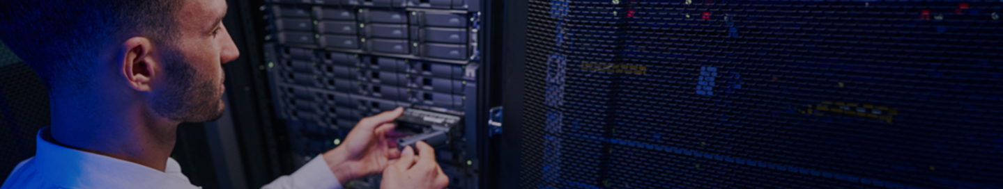 An employee working in a data center's server room.