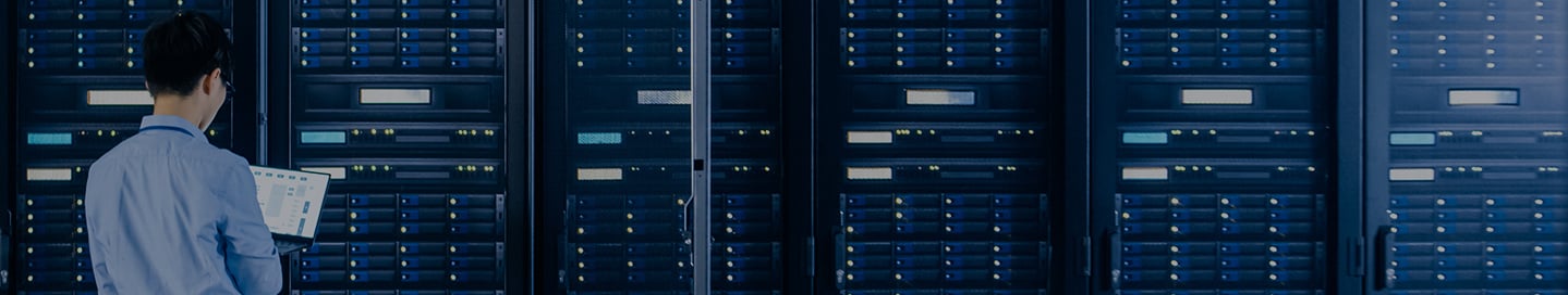 An employee working in a data center's server room. An employee working in a data center's server room.