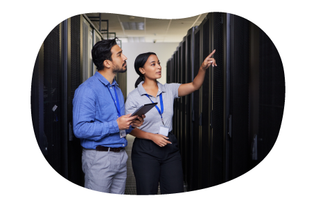Employees working in a data center's server room. Employees working in a data center's server room.