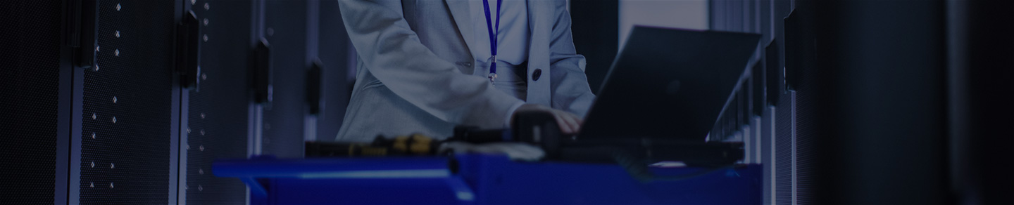 Database administrator with mobile workstation in server room.