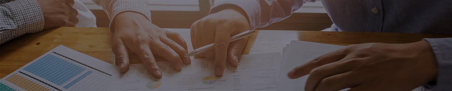 SEO and SEM consultants huddled around a desk looking at data. SEO and SEM consultants huddled around a desk looking at data.