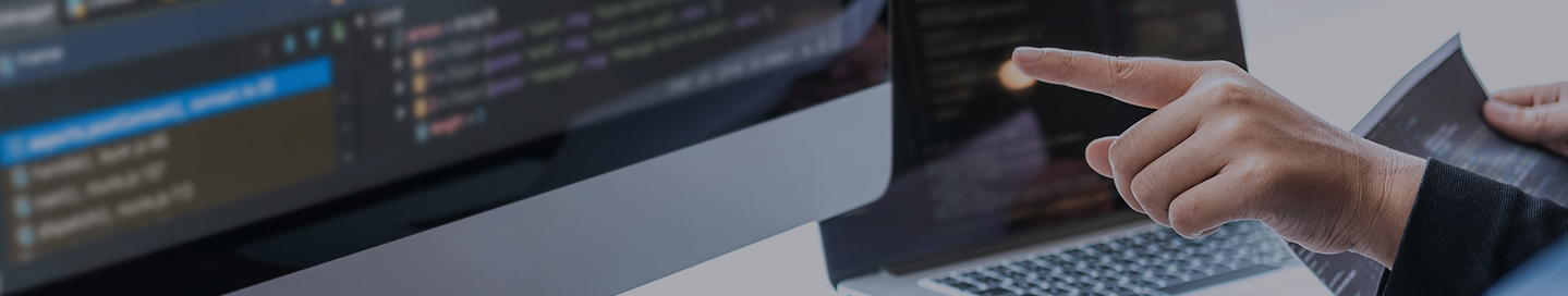 Software developer looking at code on a monitor.