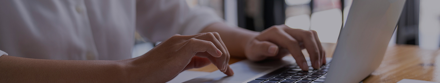 A technical writer typing on a laptop.