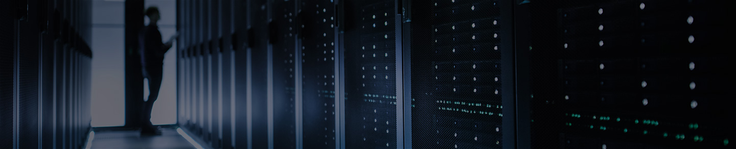 Long hallway of servers with a silhouette of a person at the end of the hallway.