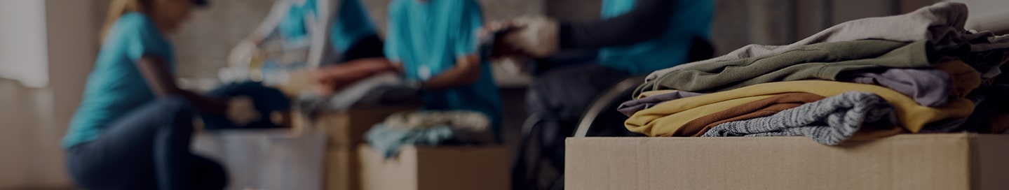 Volunteers at a nonprofit work on packages of donated clothing.