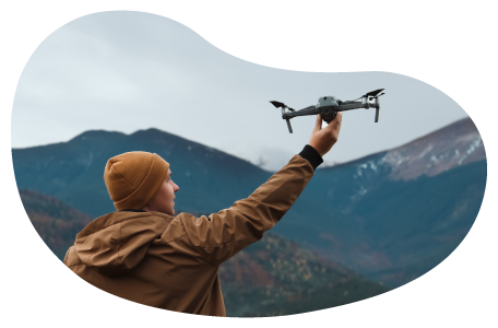 A drone photographer setting his drone off to capture a shot of the mountains 