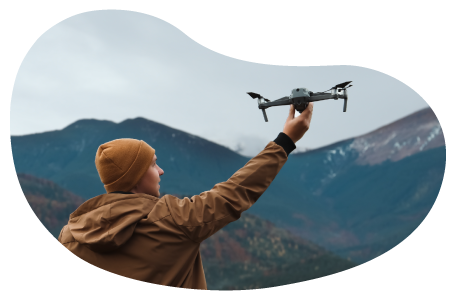 A drone photographer setting his drone off to capture a shot of the mountains A drone photographer setting his drone off to capture a shot of the mountains