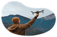 A drone photographer setting his drone off to capture a shot of the mountains 