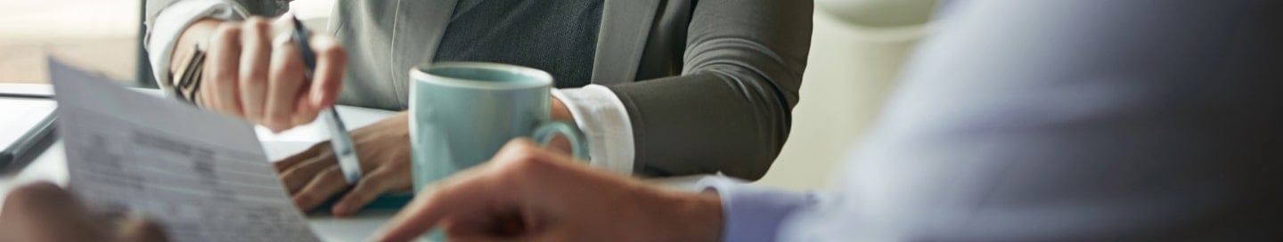 A business owner meets with a client over coffee. A business owner meets with a client over coffee.