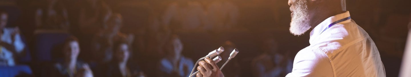 A public speaker addressing an audience from a podium. A public speaker addressing an audience from a podium.