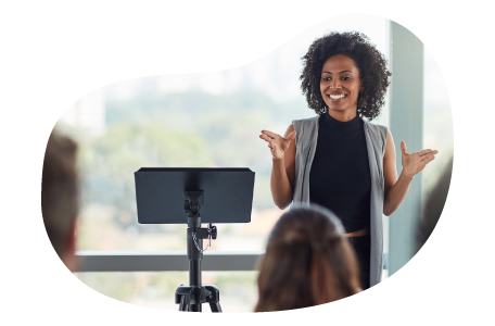 A public speaker addressing a conference room for a presentation. A public speaker addressing a conference room for a presentation.