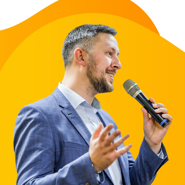 A public speaker giving a keynote presentation with a microphone in hand.