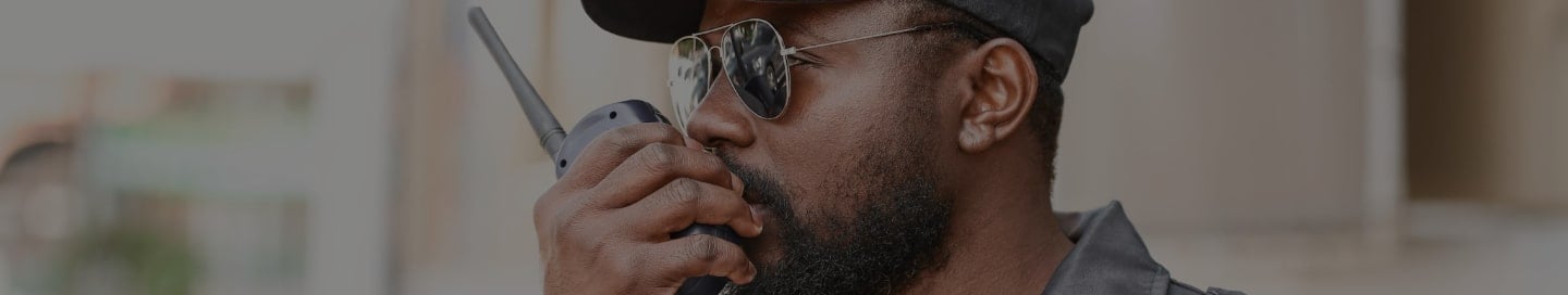 Security guard speaking into walkie talkie. Security guard speaking into walkie talkie.