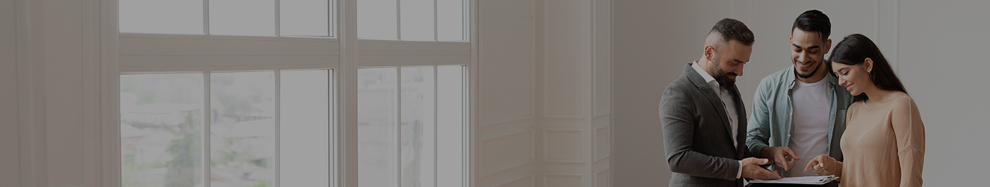 Home buyers sign an agreement with a real estate agent.