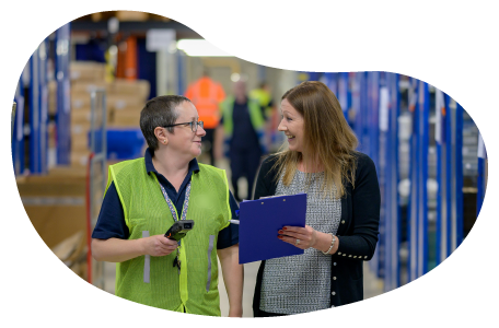 A warehouse worker chats with the owner of an Amazon storefront.