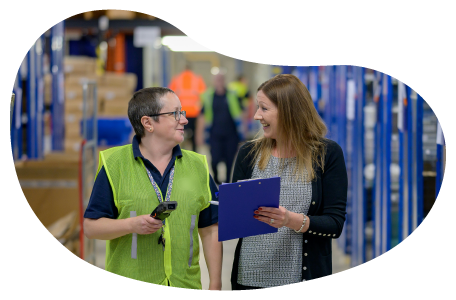 A warehouse worker chats with the owner of an Amazon storefront. A warehouse worker chats with the owner of an Amazon storefront.