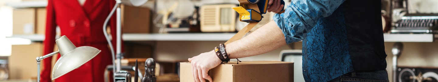 An e-commerce business owner tapes up a customer's purchase