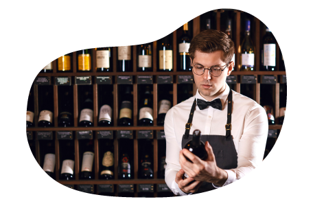 The owner of a liquor store inspects a bottle of wine.