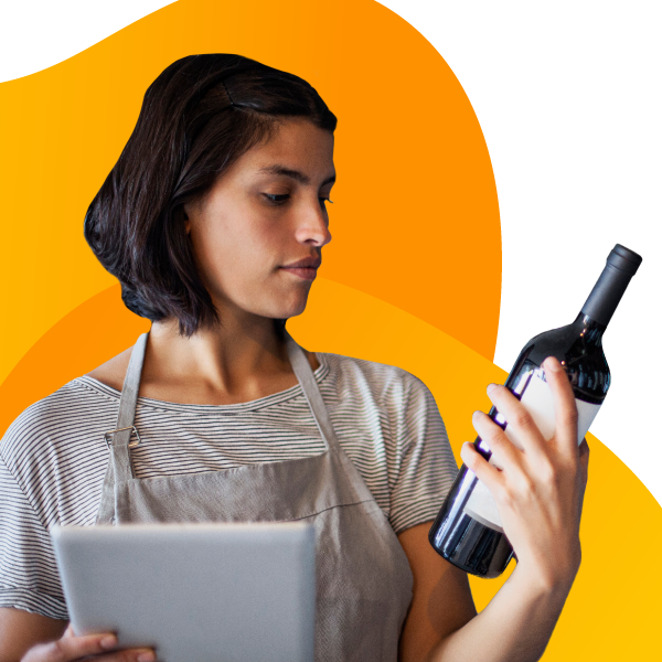 A business owner inspects a bottle of wine.